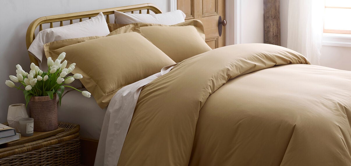 Image of bed made with gold bedding